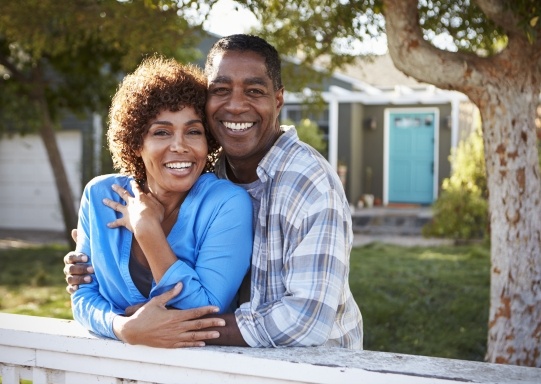 Man and woman with dental insurance smiling outdoors