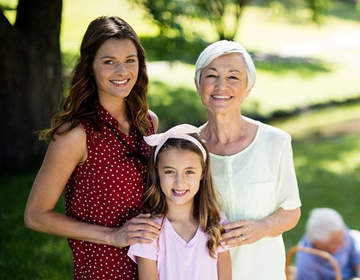 Mother daughter and granddaughter smiling outdoors