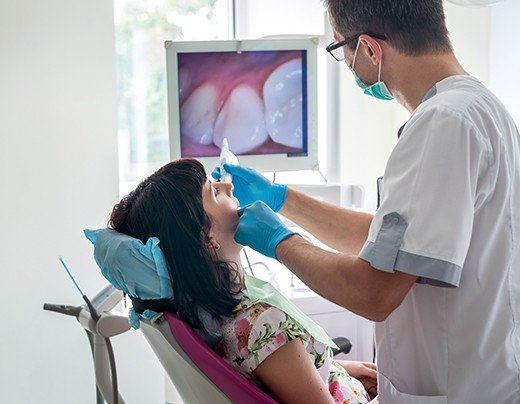 Dentist and patient looking at intraoral images on computer screen