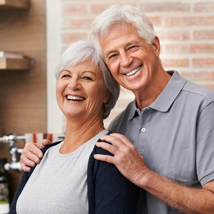 Older man and woman sharing smile after restorative dentistry