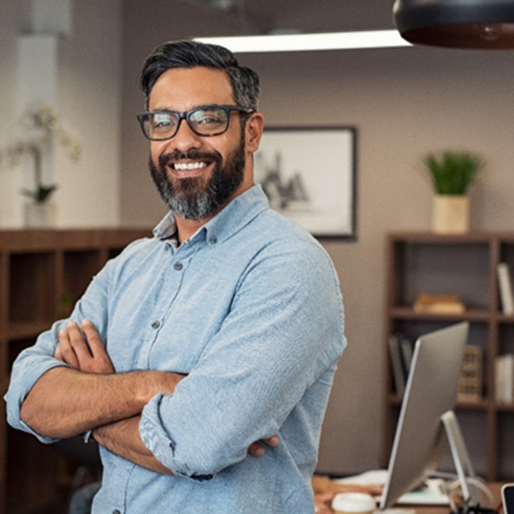 Bearded man standing in an office and smiling
