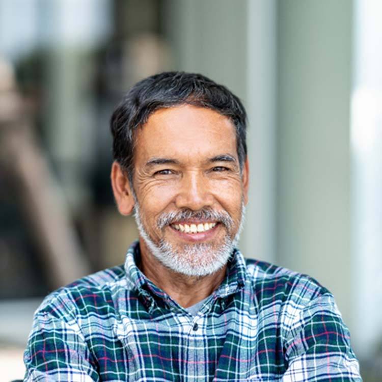 man in a plaid shirt smiling with dental crowns in Boerne, TX 