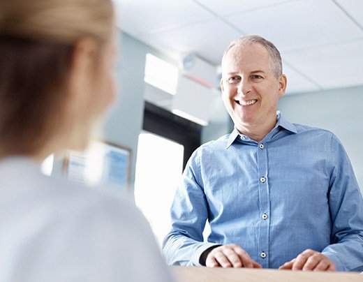 Man checking in at dental office reception desk