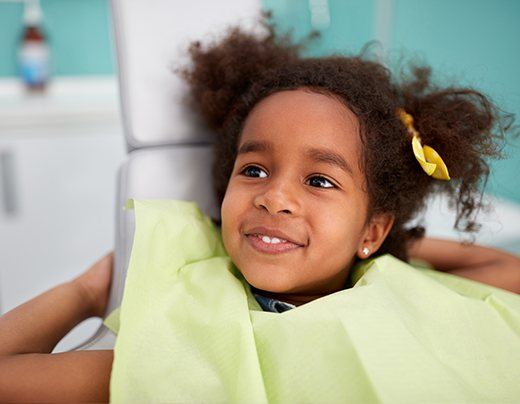 Little girl smiling at first dental checkup