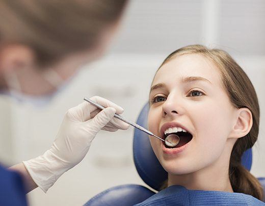 Child receiving examination after tooth-colored filling placement