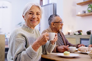 Happy senior woman sitting at table with friends