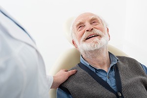 Happy senior patient looking up at his dentist