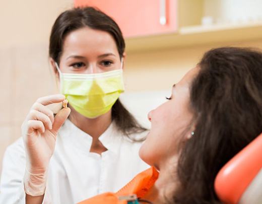 Dental team member holding patient’s extracted tooth