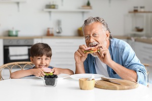 a grandparent eating lunch with their grandchild