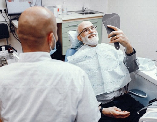 dental patient admiring his smile in a mirror