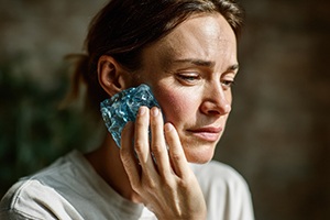 Woman with a cold compress on her cheek