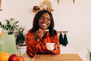 Woman eating yogurt and smiling