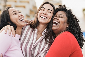 Three women laughing and smiling together
