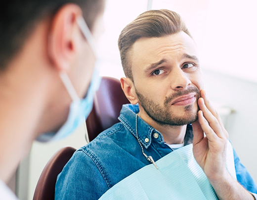 Pained man visiting his Boerne emergency dentist 