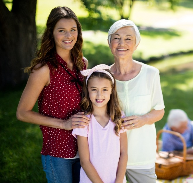 Mother daughter and granddaughter smiling outdoors