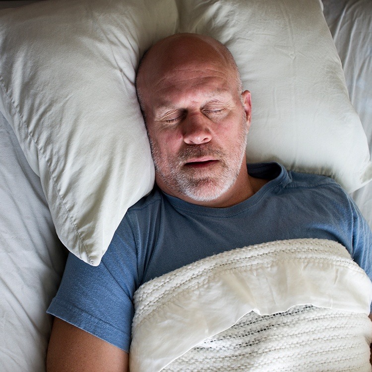 Man sleeping soundly thanks to sleep apnea therapy