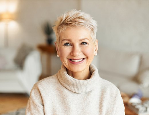 Woman in sweater smiling in her living room