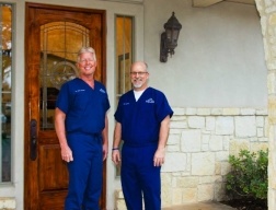 Boerne Texas dentists smiling by dental office entrance