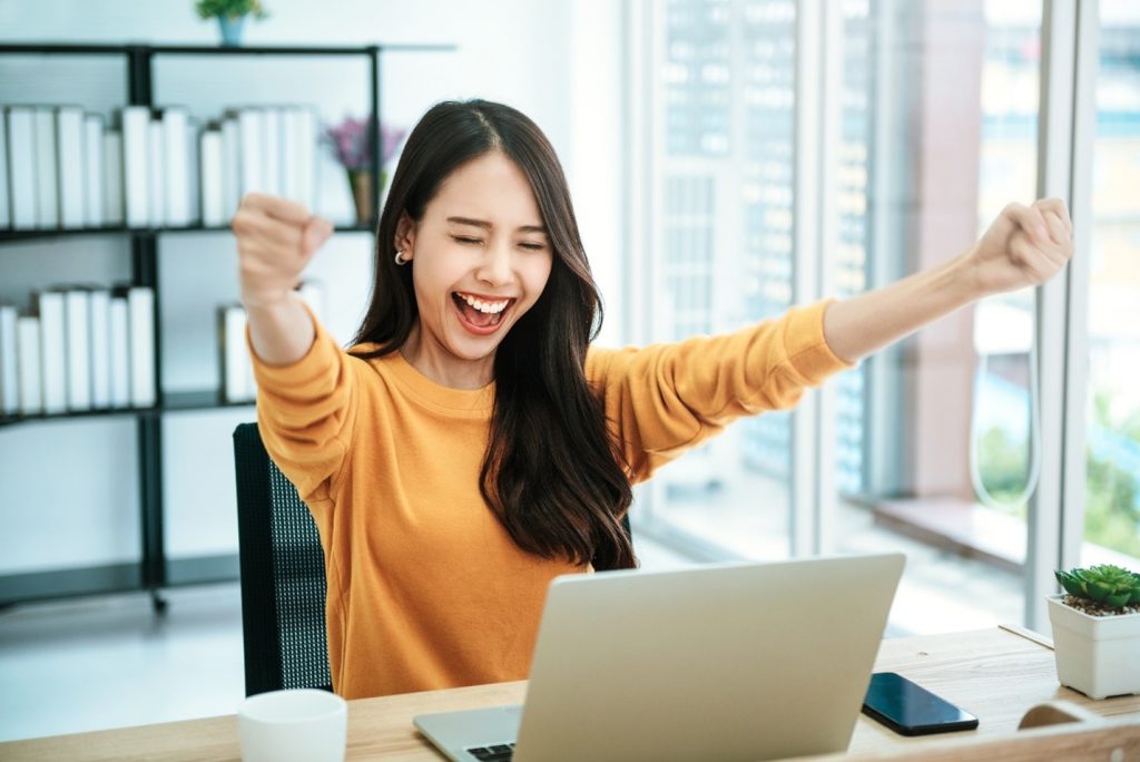 Woman excited about her tax refund in her office