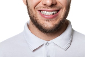 Adult man smiling with a missing tooth