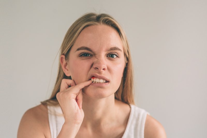 Patient scratching at their dental implants
